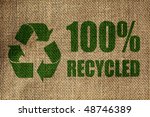 Small photo of Recycling symbol and one hundred per cent recycled sign on the side of a hessian bag in green