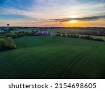 Small photo of Sunset over agricultural fields in rural Kentucky between cities of Lexington and Nicholasville with a barn between tree lined pastures.