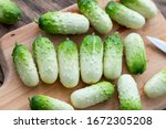 Small photo of Small fresh snack cocktail Dutch cucumbers Quirk variety on wooden background, healthy vegetarian organic food concept