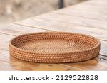 Small photo of round rattan basket isolated on wooden background