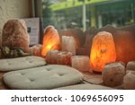 seat in the middle of a lot Himalayan salt lamps and tealights closeup