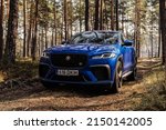 Small photo of Riga, Latvia 26 April 2022 NEW JAGUAR Fâ€‘PACE SVR EXTERIOR F-PACE SVR's design includes larger air intakes, bonnet vents, side fender vents and rear spoiler. Stands on forest road. Front view.