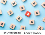 Small photo of Red wooden cube with person icon stand out from the crowd on blue background. Dissenting opinion, divergent views and different concepts