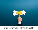 Small photo of Businessman hand connecting yellow puzzle pieces. joint venture, partnership, Mergers or acquisition concept