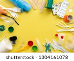 White single-use plastic and other plastic items on a yellow background. The concept of choice without plastic or environmental problems.