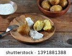 Baked Potatoes On A Wooden...
