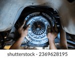 Small photo of Mechanic's hand installing new clutch plate in car, clutch system, auto mechanic in garage,service clutch system.