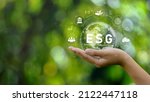 Small photo of ESG icon concept. Environment in renewable hands. Nature, earth, society and governance SG in sustainable business on networked connections on green background. environmental icon