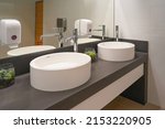 Interior of bathroom with washbasin and faucet. Public bathroom in the airport or restaurant, cafe. Bathroom interior sink with modern design in luxury hotel