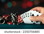 Poker cards with straight flush combination. The player hand holds a winning combination in a game in a poker club. The concept of luck in the poker game.