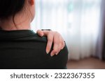Small photo of Young asian woman massages her tense neck and shoulder for relief,easing tense muscle.