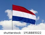 Netherlands flag isolated on the blue sky with clipping path. close up waving flag of Netherlands. flag symbols of Netherlands.