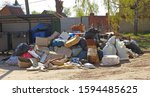 Small photo of Zaraysk, Russia - 1 May, 2019: a huge pile of household rubbish piled up next to empty trash cans. Boorish attitude of people towards nature. Environmental disaster in the world of consumption