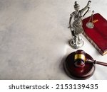 Symbols of American justice - a figurine of the goddess of justice - Themis, a judge's gavel and a book - the Holy Bible on a white background. Low angle view. There is free space to insert.