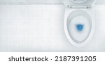 Small photo of Top view of toilet bowl, blue detergent flushing in it