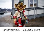Small photo of TROMSO, NORWAY - MAY 16, 2022: Stone figure of a Troll with the flag of Norway on a street in Tromso at the entrance to a store. Trolls are evil characters in popular Scandinavian folklore. Editorial