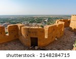 Small photo of Jaisalmer, Rajasthan, India - October 13, 2019 : Great walls of Jaisalmer Fort or Sonar Quila or Golden Fort, made of yellow sandstone, in the morning light with city in the background. UNESCO site.