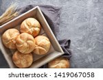 Crusty round bread rolls, known as Kaiser or Vienna rolls on linen towel, flat lay on rustic background with copy-space