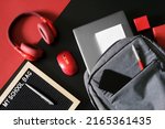 Gray urban backpack with laptop, pen, notepad and smartphone on a black and red next to headphones, mouse and the inscription my shool bag. Concept of portfolio modern schoolboy or student. Close-up