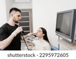Small photo of ENT doctor using fibrolaryngoscope to examine and treat nose. ENT specialist diagnoses and treats larynx and pharynx, such as hoarseness, vocal cord nodules, tumors, infections, and inflammation