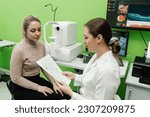 Small photo of Consultation with optometrist with optical coherence tomography OCT scan to create pictures of the back of eye. Examination of eyes of patient using optical coherence tomograph