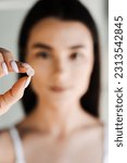 Small photo of Girl with acne round patch in hand close-up. Using acne patches for treatment of pimple and rosacea close-up. Facial rejuvenation cleansing cosmetology