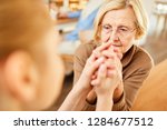 Small photo of Nursing lady consoles a demented or depressed elderly woman and holds her hand