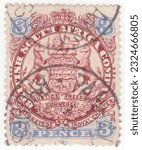 Small photo of RHODESIA - 1896: An 3 pence red-brown and ultramarine postage stamp depicting Arms of the British South Africa Company. The ends of ribbons containing motto cross the animals legs
