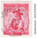 Small photo of AUSTRIA - 1951: 1.45 shilling dark carmine postage stamp depicting Women's clothing from Wilten. A young attractive girl in a hat with wide brims dreamily contemplates a mountain view