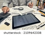 Small photo of Businessman working with document, spreadsheet, using calculator, tablet pc. Office desk closeup. Business analysis and accounting concept