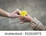 Parent and child hands handing yellow flowers