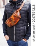 Small photo of A cropped beyond recognition man holding his new brown leather banana bag in the city. Men's Leather Hip Bag Over the Shoulder Waist Bag made of genuine leather.