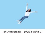 Young beautiful smiling asian girl floating in mid-air relaxing isolated on blue background. 