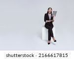 friendly face asian businesswoman smile in formal suit sitting on chair her using tablet and looking to copyspace isolated on white background studio shot.