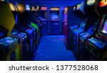 Old Vintage Arcade Video Games in an empty dark gaming room with blue light with glowing displays and beautiful retro design on a wide landscape photo