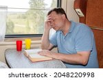 Small photo of man fell asleep while reading a book in his compartment car got seasick on the train.