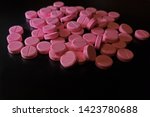 Small photo of Pink Nitroglycerin pills scattered on solid black background - 002