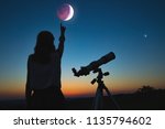 Small photo of Girl looking at lunar eclipse through a telescope. My astronomy work.