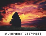 Silhouette of a girl watching the clouds after sunset.