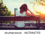 Girl enjoying city view from a bench in sunset / sunrise time.
