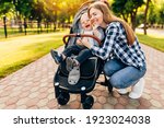 Young beautiful mother, with her little cute child, walking in the park on a sunny summer day.