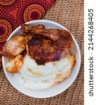 Small photo of Popular and simple South African Fast food or street food, roasted chicken and pap or maize meal on a rustic surface