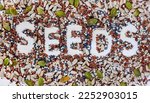 Small photo of Seeds of goodness. Seeds written in a mix of health seeds on light wood