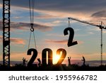 Silhouette of construction worker with crane and cloudy sky for preparation of welcome 2022 new year party and change new business.