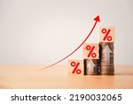 Increasing coin stacking with up arrow and percentage sign for increase financial interest rate and business investment growth from dividend concept.