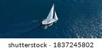 Aerial drone ultra wide photo of beautiful sailboat cruising deep blue open ocean Mediterranean sea