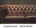 Vintage brown leather sofa with grunge gray wall living room.