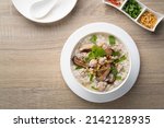 Small photo of Boiled Rice porridge with minced pork and shiitake mushrooms.Thai rice soup(Khao Tom moo sap).popular breakfast in asian.Top view