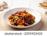 Stir fried crispy shrimp with cashew nuts and sweet pepper in white plate.Thai food not spicy.