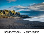Black Beach and Sea-stacks in Vik Iceland with mountains waves a